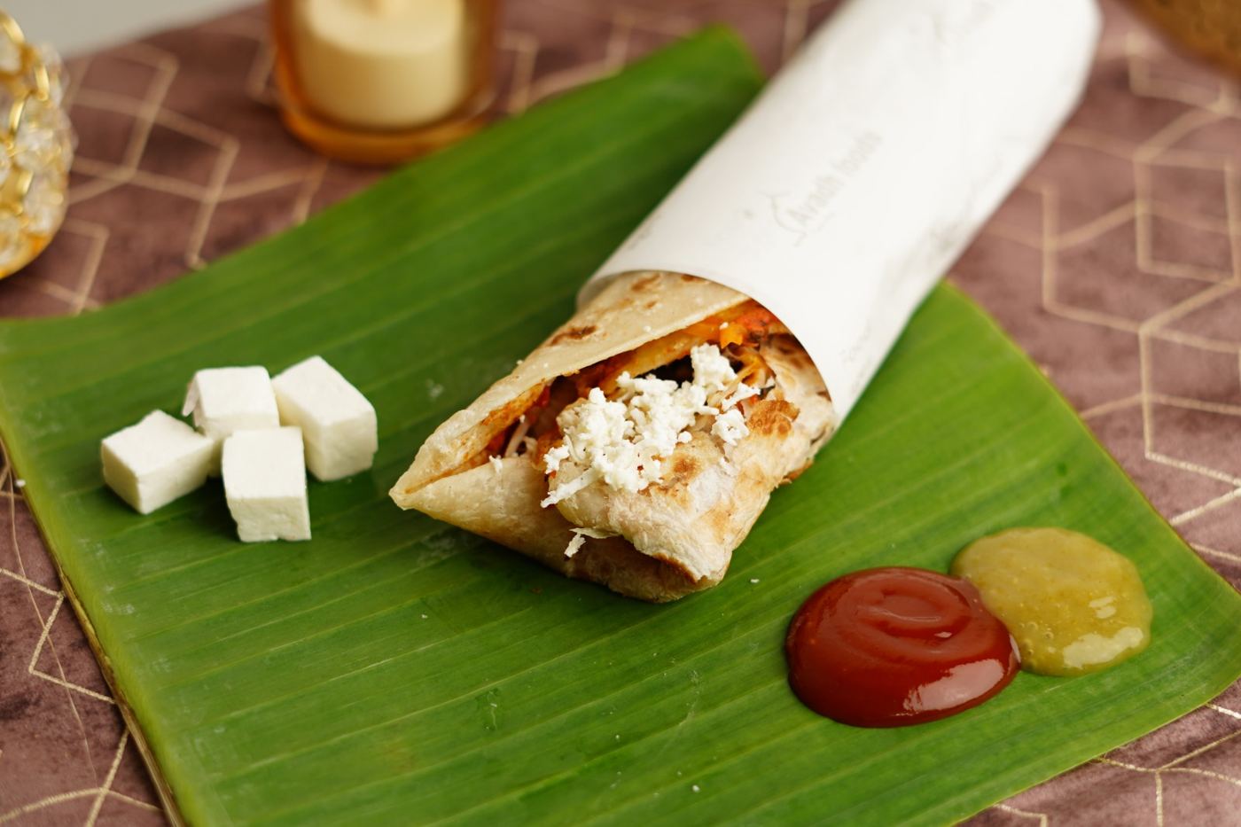 Paneer roll wrapped in Avadh Foods paper with paneer cubes and sauces